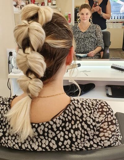 Coiffure attachée formée de larges boucles sur cheveux blonds