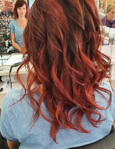 Cheveux roux mi-longs coiffés en boucles