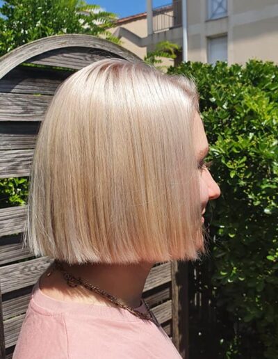 Cheveux blonds très clairs, longs et lisses, vus de profil