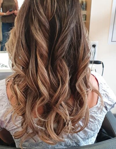Cheveux longs bruns ondulés aux mèches plus claires