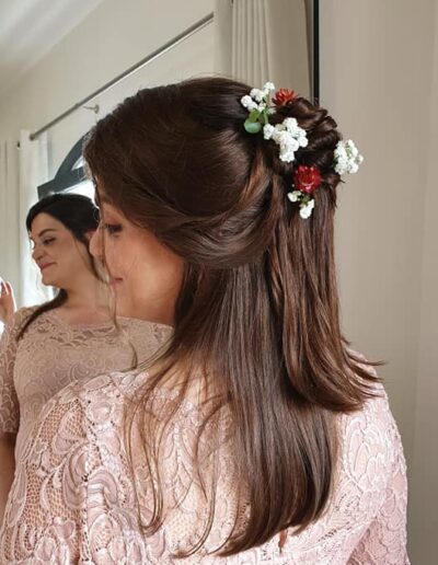 Coiffure brune partiellement attachée avec un accessoire floral