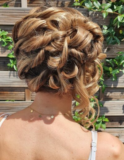 Chignon blond composé de boucles et de mèches entrelacées