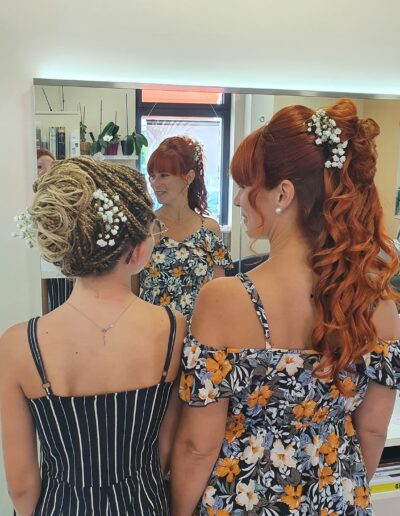 Deux coiffures attachées, blonde et rousse, vues de dos