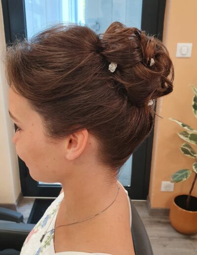 Chignon brun relevé avec de petits ornements clairs