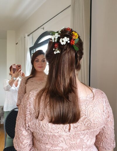 Cheveux longs bruns partiellement attachés et ornés de fleurs
