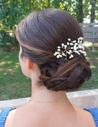 Coiffure attachée sur cheveux bruns avec un accessoire à petites fleurs blanches