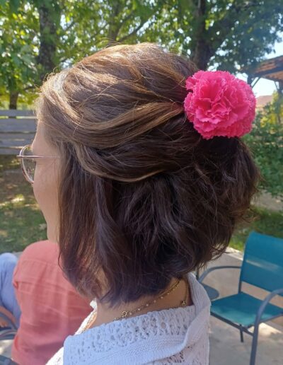 Demi-attache sur cheveux bruns ornée d’une fleur rose